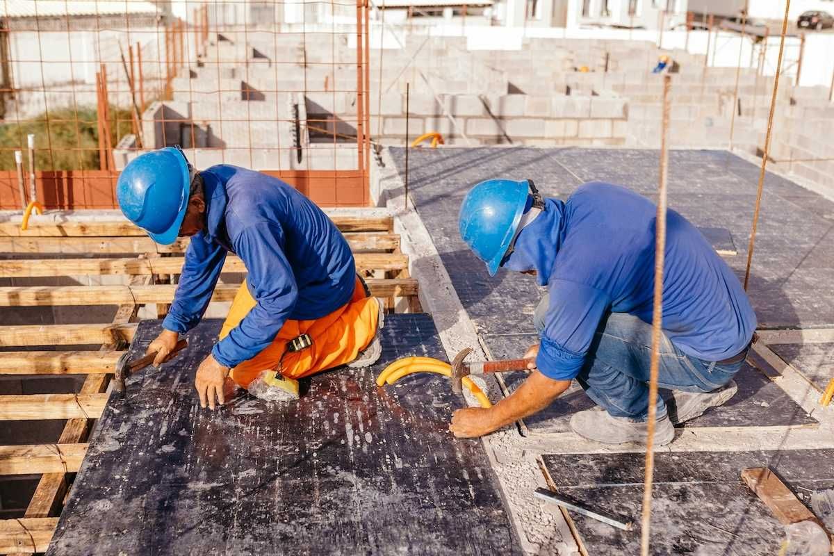 Two construction workers on a hot roof