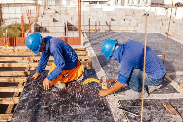 Two construction workers on a hot roof