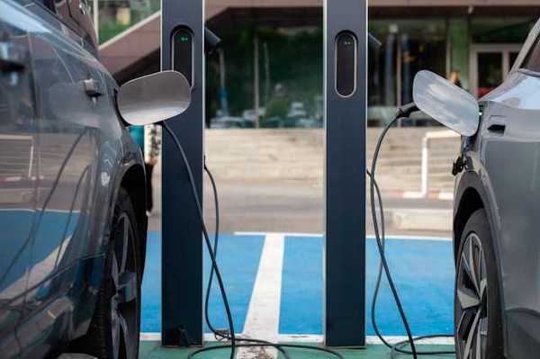 Two electric vehicles parked next to one another while being charged