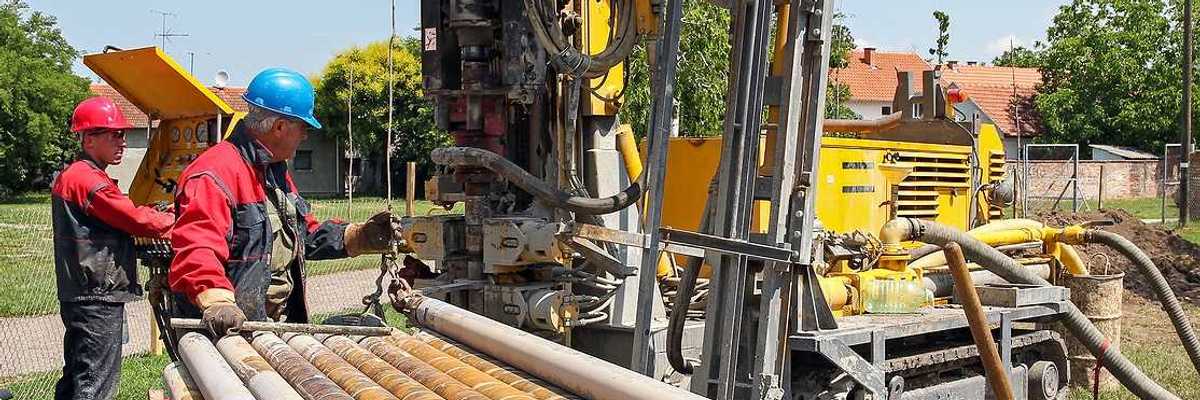 Two men drilling a geothermal well for a residential geothermal heat pump.