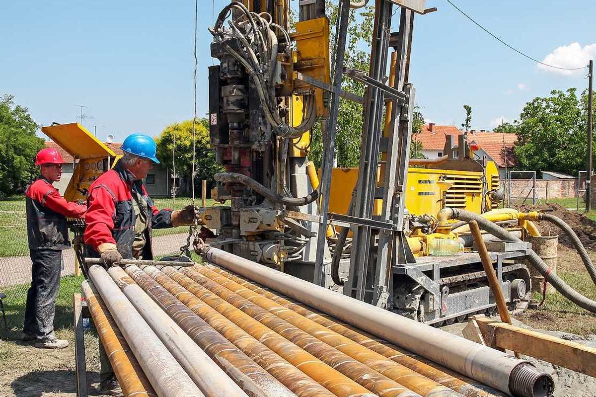 Two men drilling a geothermal well for a residential geothermal heat pump.