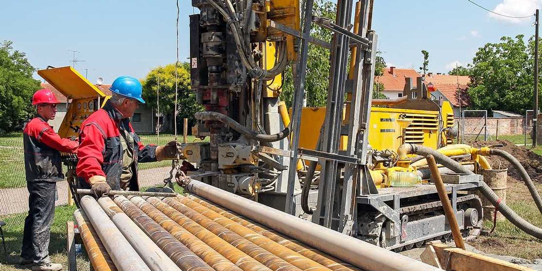 Two men drilling a geothermal well for a residential geothermal heat pump.
