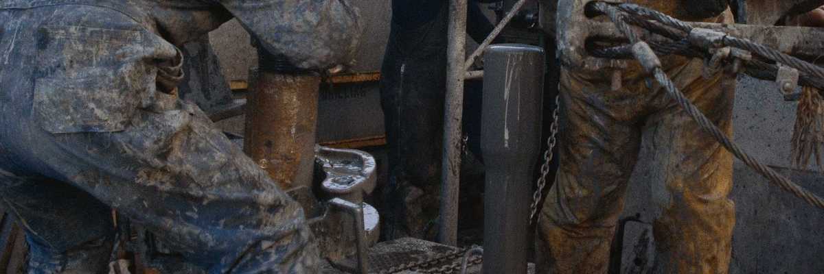 Two oilfield workers working on drilling equipment