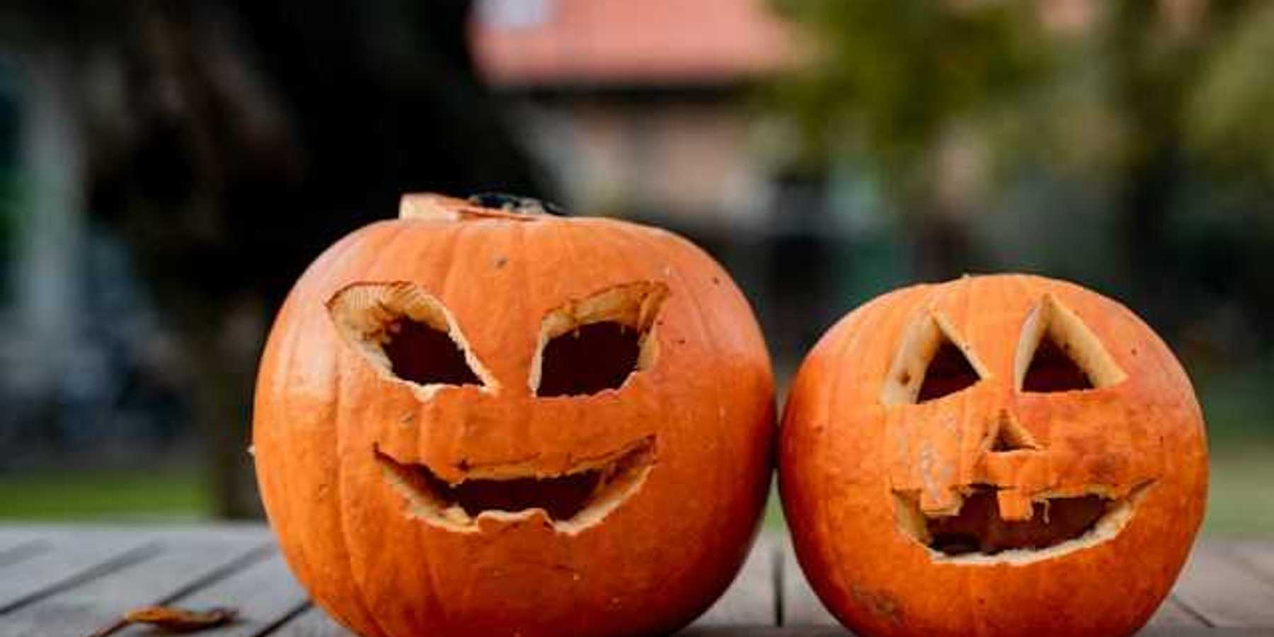 Two orange pumpkins with faces carved into them