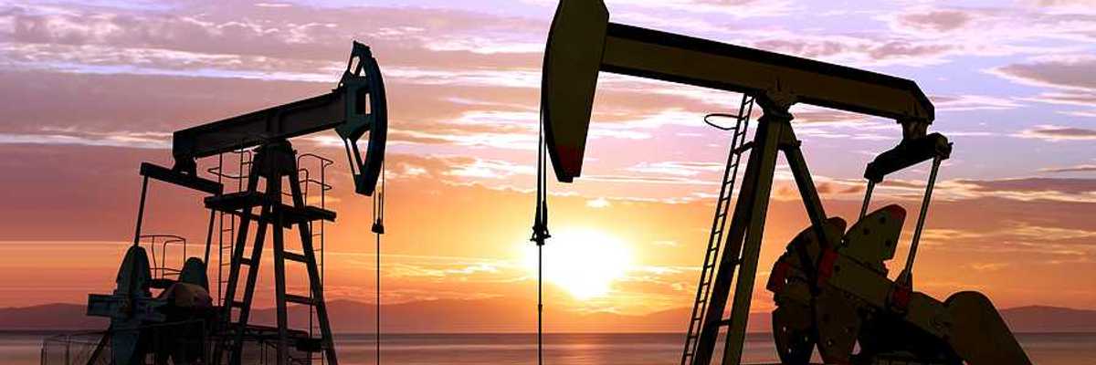 Two pump jacks against a sunset