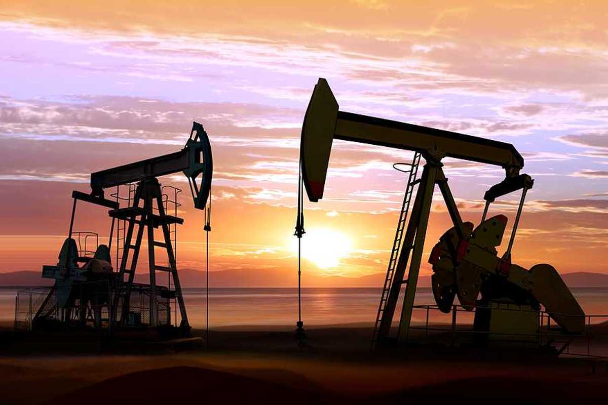 Two pump jacks against a sunset