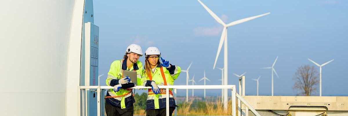 Two renewable energy engineers working on a wind turbine.