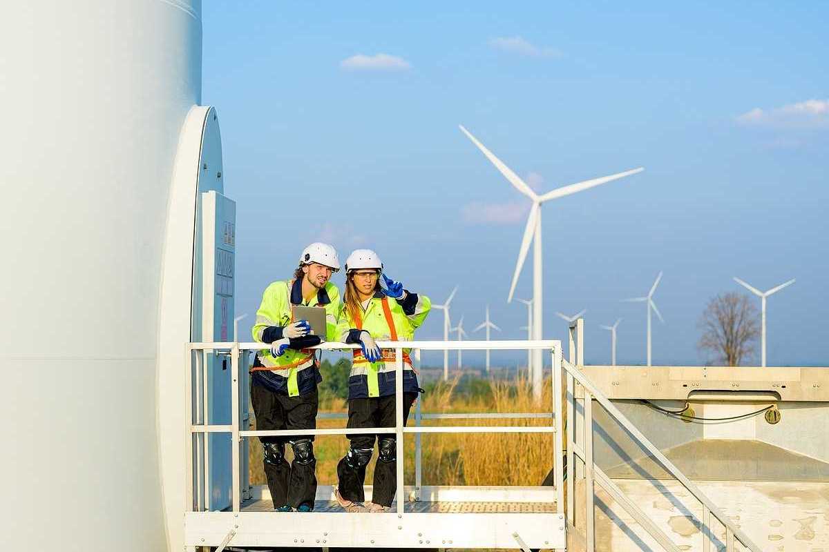 Two renewable energy engineers working on a wind turbine.