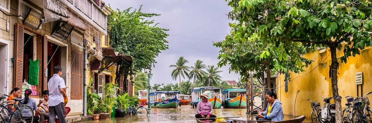 Two women in a boat on a flooded street in Vietnam