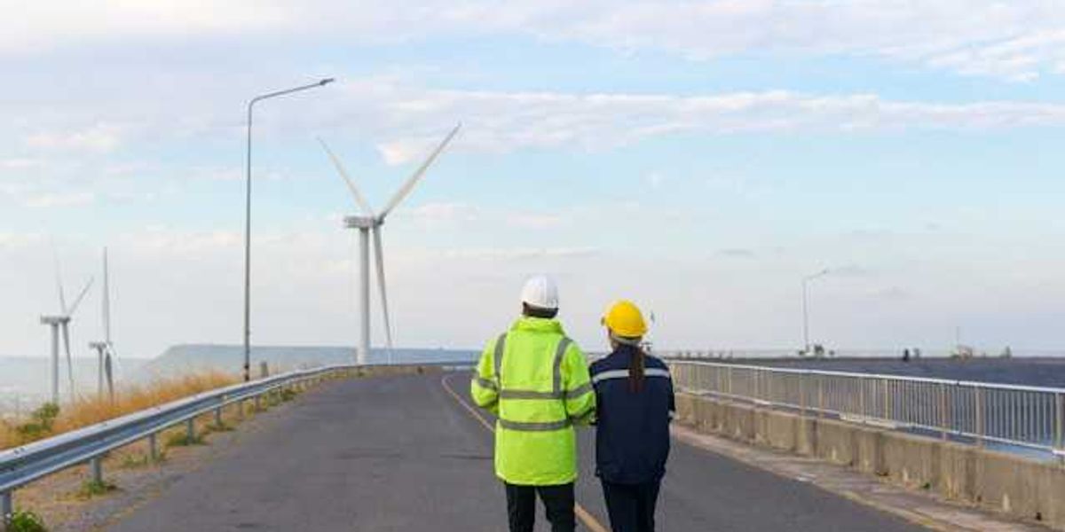 Two workers looking at wind turbines