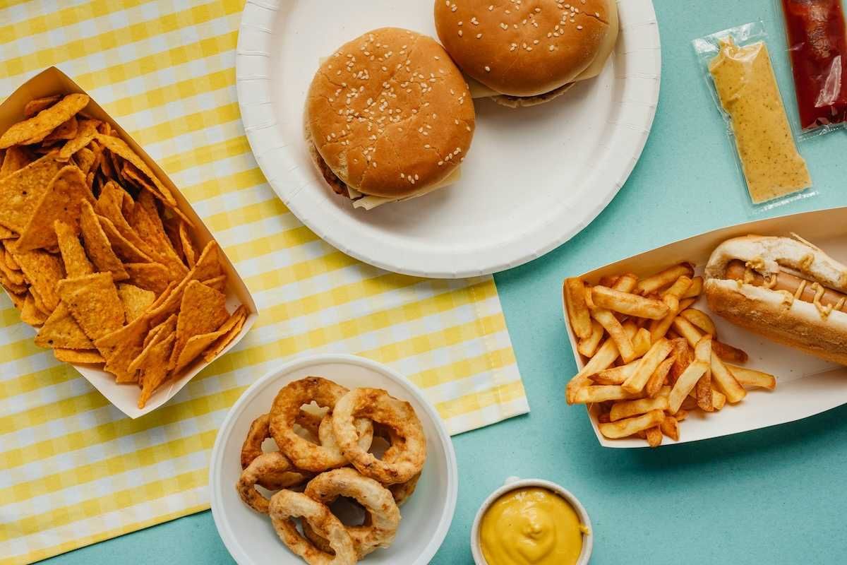 Ultra-processed food: Tortilla chips, fried onion rings, french fries, cheese burgers, and hot dog.