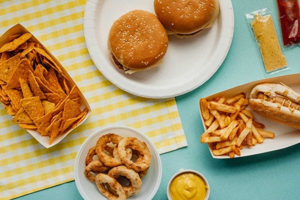 Ultra-processed food: Tortilla chips, fried onion rings, french fries, cheese burgers, and hot dog.