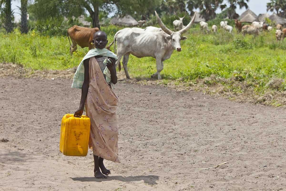 Unidentified woman carries a large water jug to get water from the Nile in South Sudan.