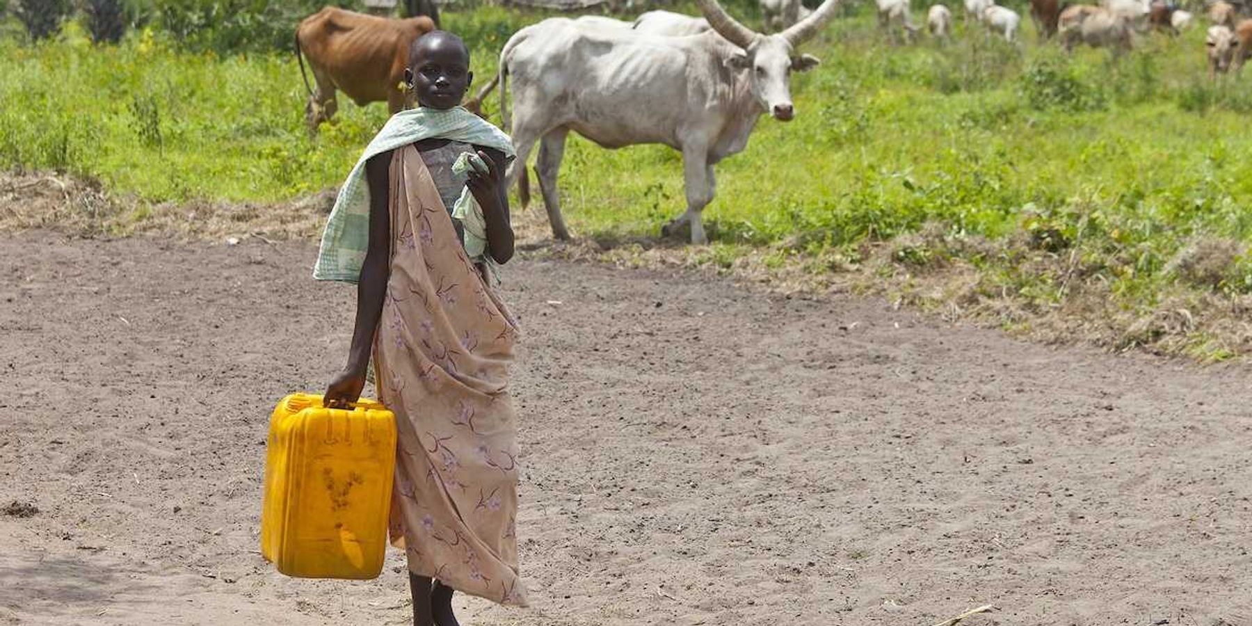 Unidentified woman carries a large water jug to get water from the Nile in South Sudan.