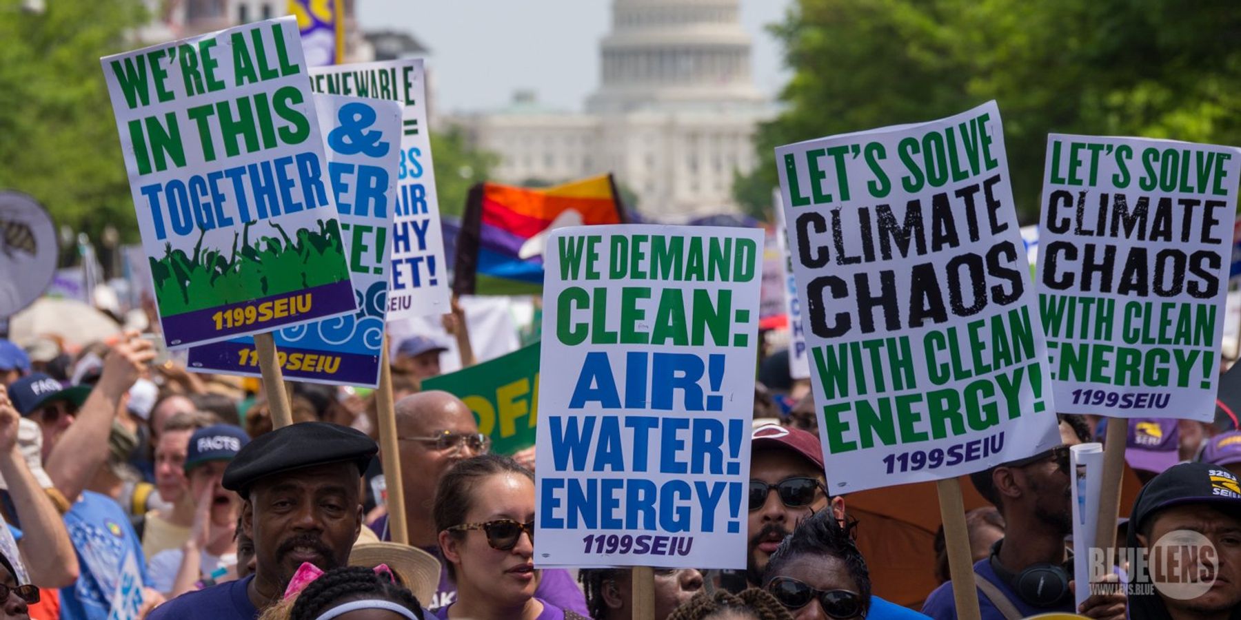 Union workers from SEIU holding climate protest signs at a rally in Washington DC