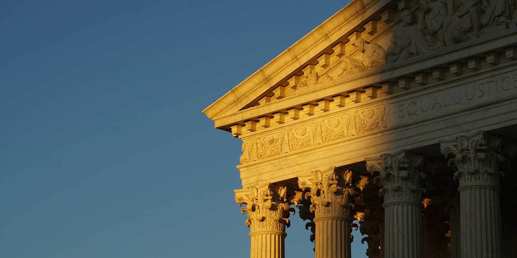 US Supreme Court roof and pillars in evening sun and shadow.