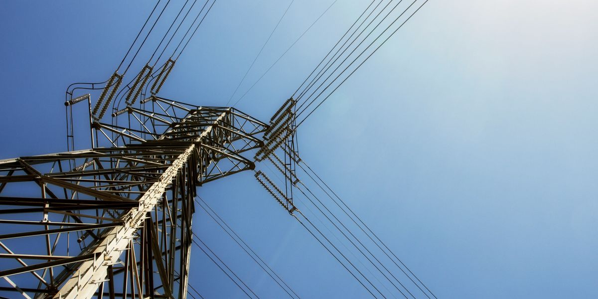 Utility tower with electric cables stretching away from it.