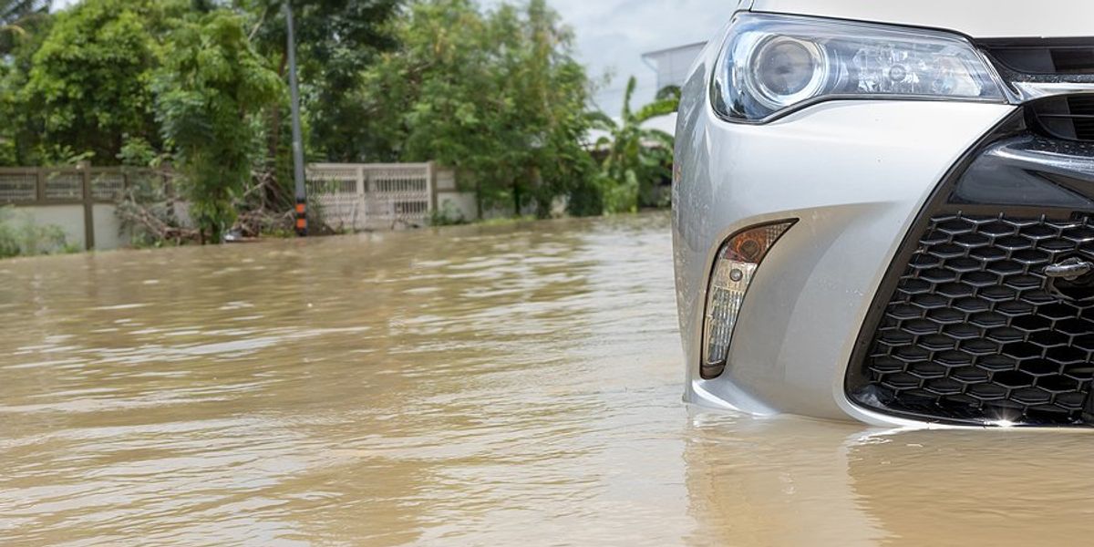 View of the front of a car that is standing in flood waters.