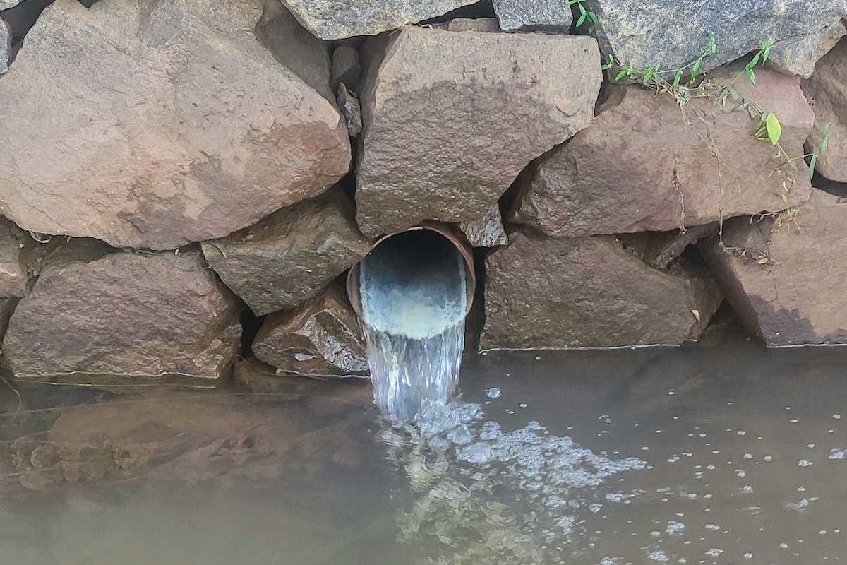 Wastewater flowing from outflow into pond