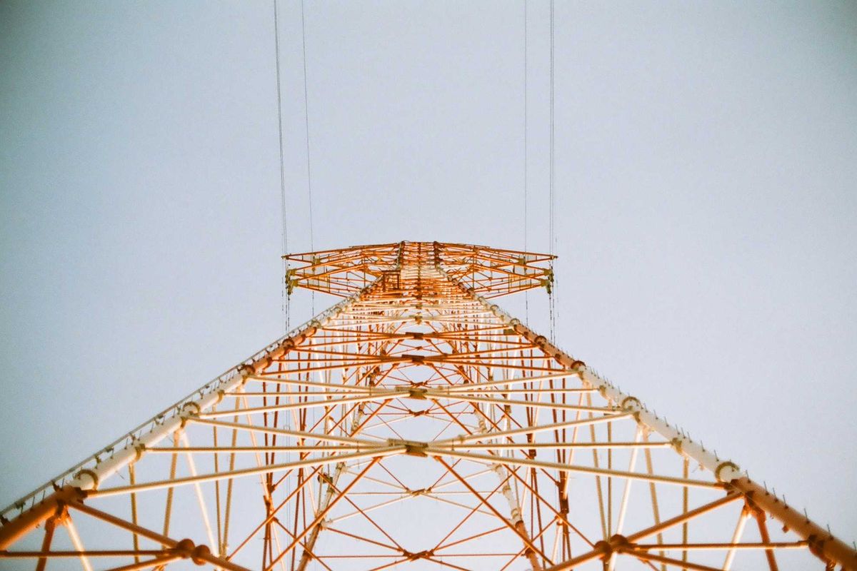 white and brown metal utility tower viewed from below