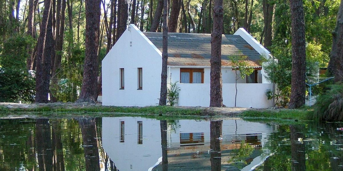 white house on forest with floodwaters in foreground.