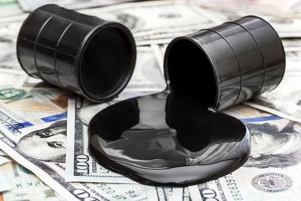 Whole barrel of oil and crude oil spilled from barrel on 100 dollar bills