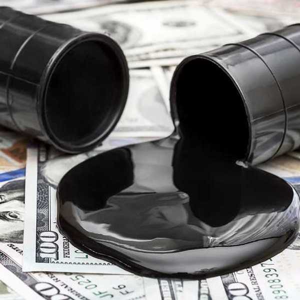 Whole barrel of oil and crude oil spilled from barrel on 100 dollar bills
