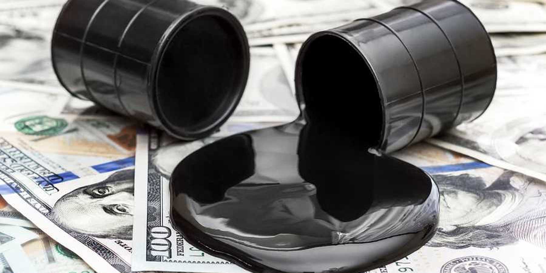 Whole barrel of oil and crude oil spilled from barrel on the dollar bills.