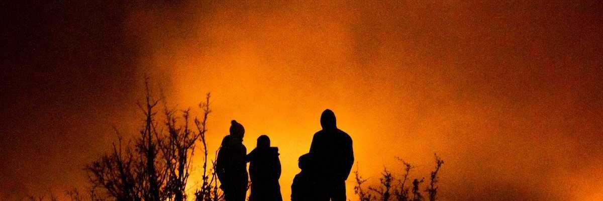 Wildfire observers silhuouetted against glowing horizon