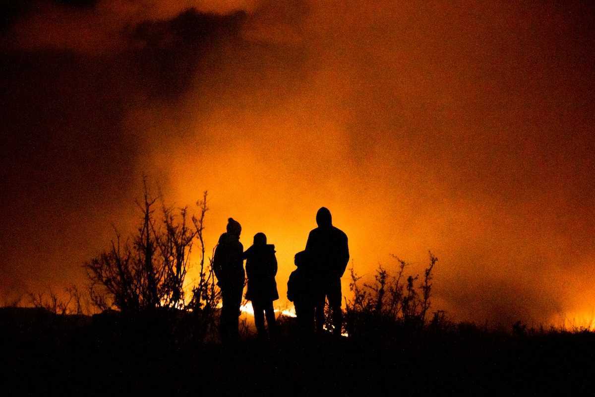 Wildfire observers silhuouetted against glowing horizon