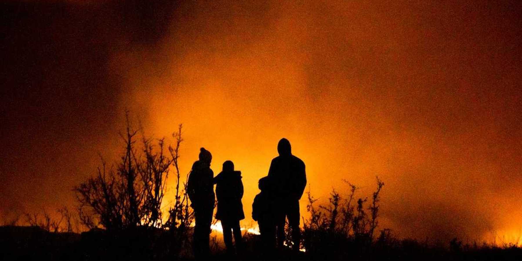 Wildfire observers silhuouetted against glowing horizon