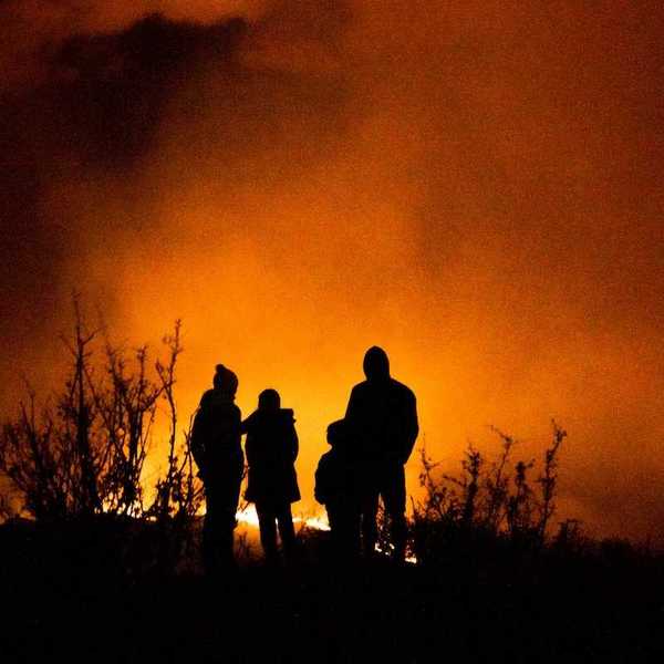 Wildfire observers silhuouetted against glowing horizon