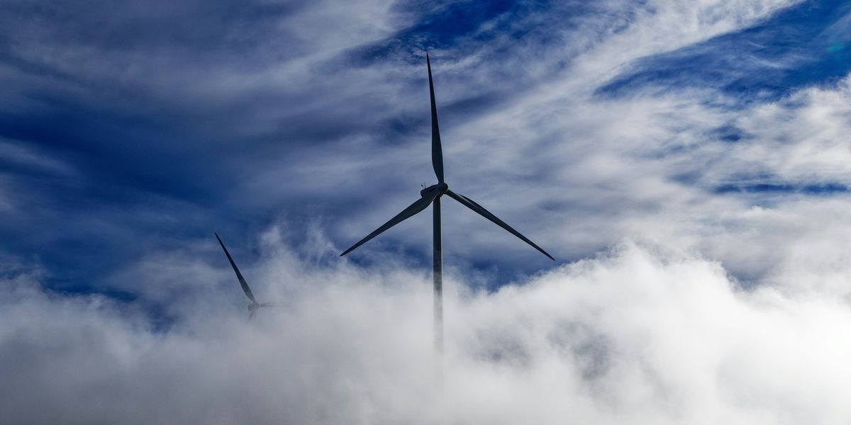 wind turbine on green grass field under white clouds.