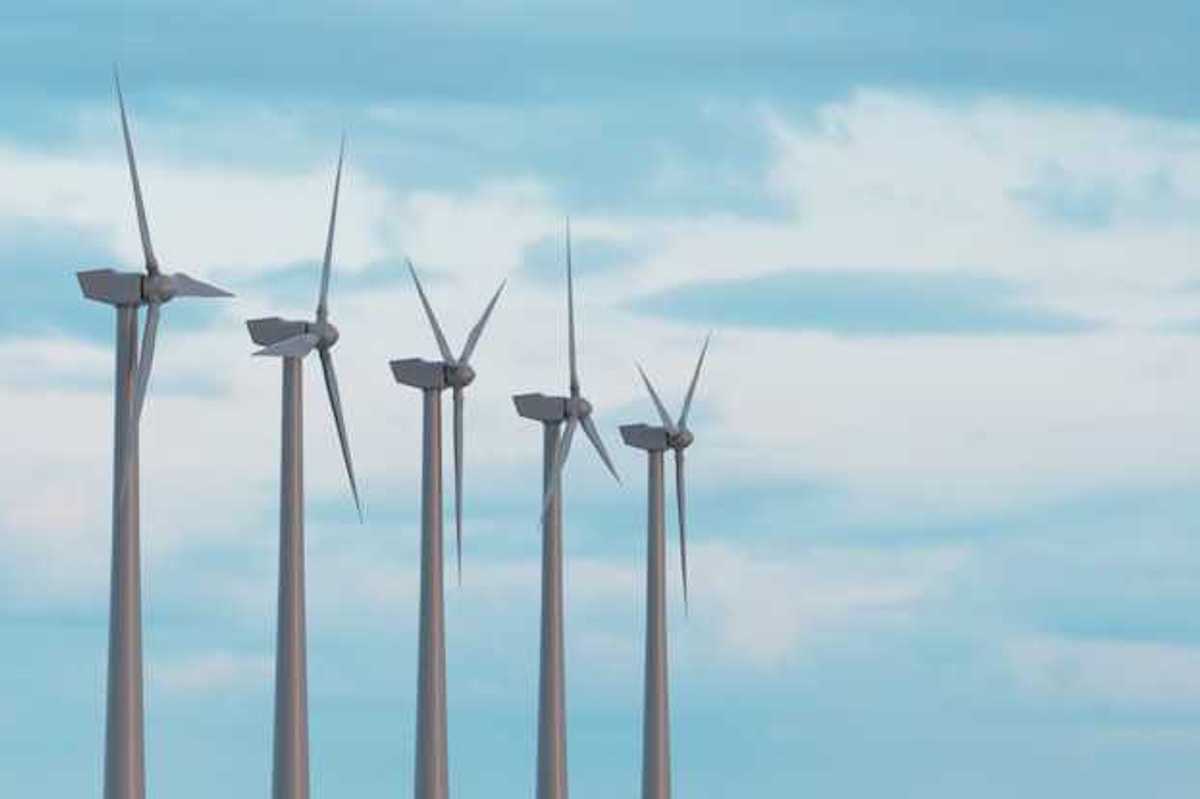 Wind turbines in a row against a blue sky