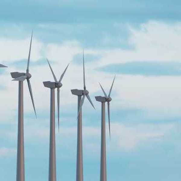 Wind turbines in a row against a blue sky
