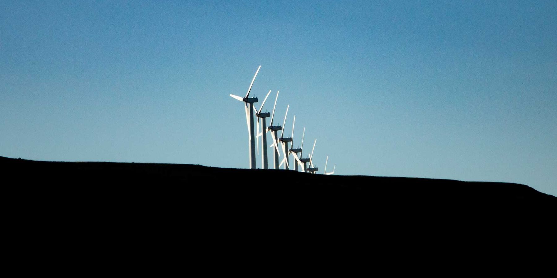 wind turbines under blue sky during daytime