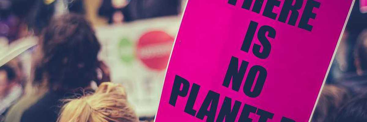 Woman carrying a sign saying There is no planet B