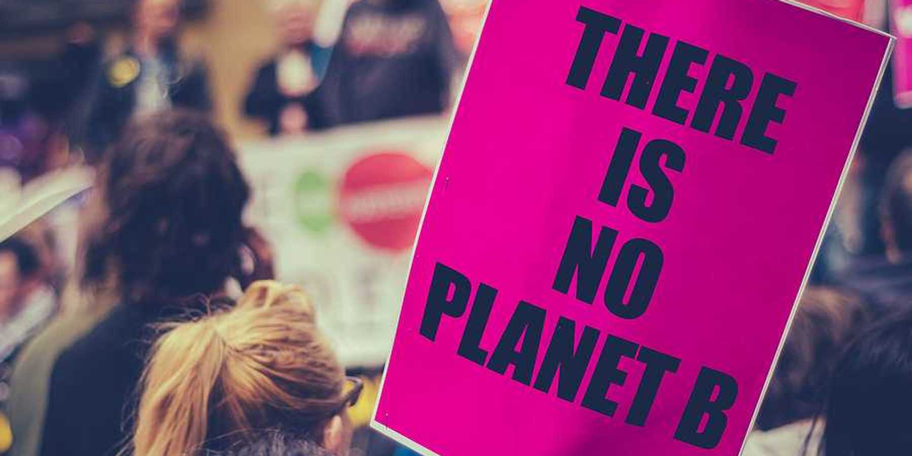 Woman carrying a sign saying There is no planet B
