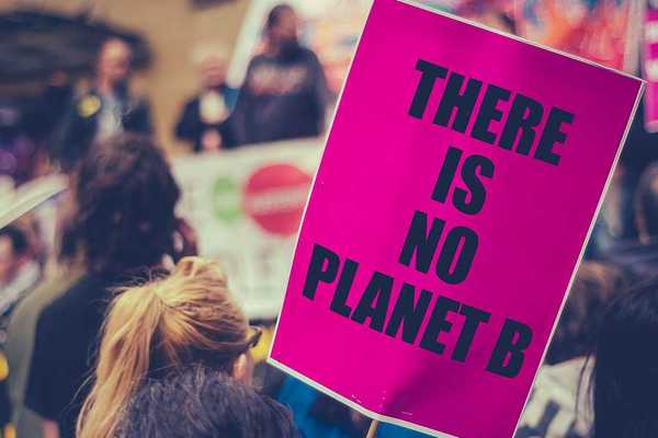 Woman carrying a sign saying There is no planet B