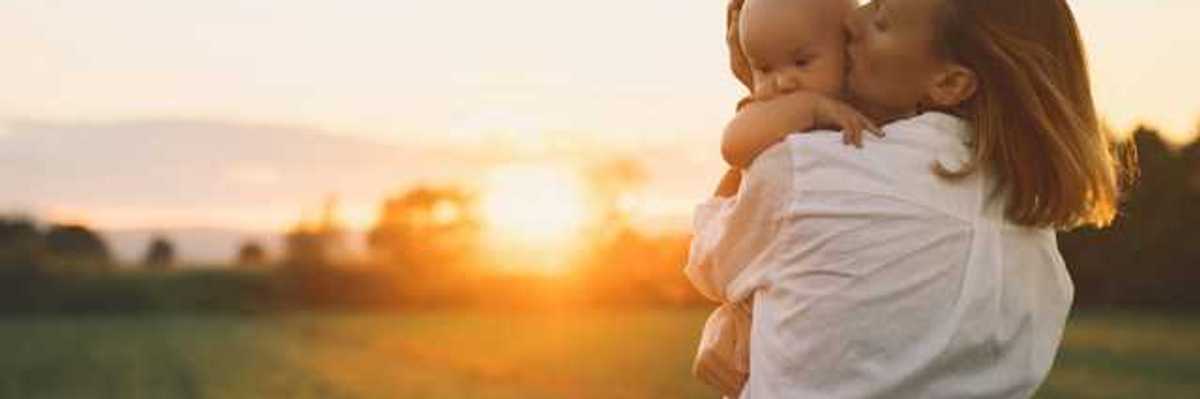 Woman holding a baby in a golden field