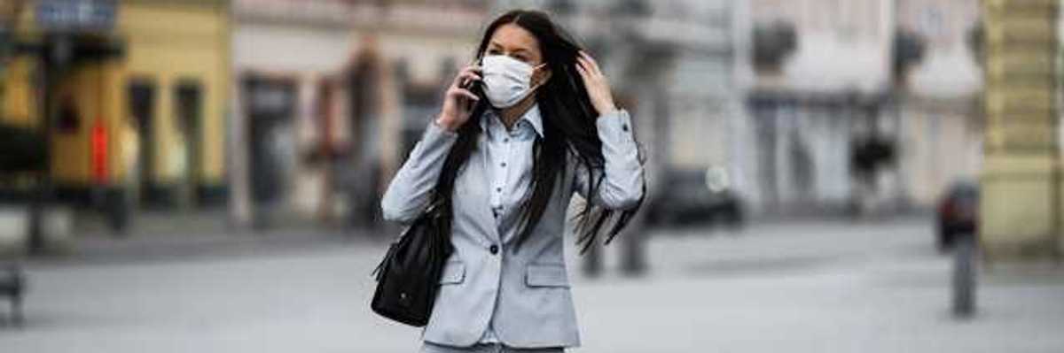 Woman in business suit with a protective mask over her face