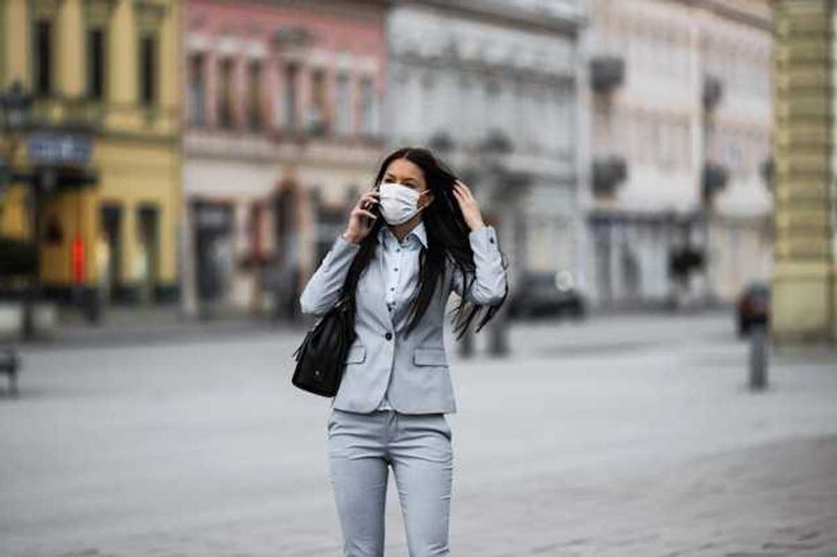 Woman in business suit with a protective mask over her face