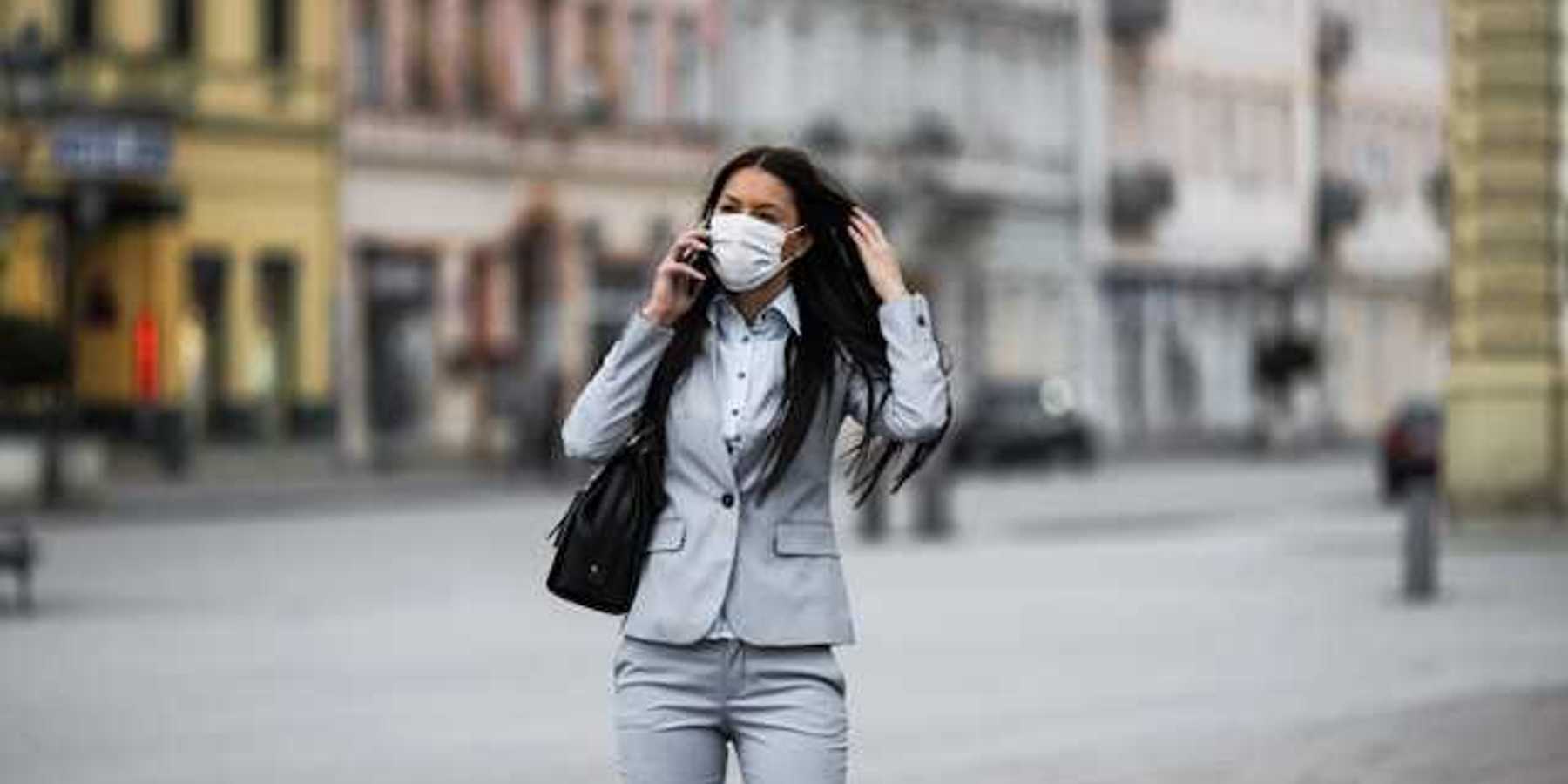 Woman in business suit with a protective mask over her face