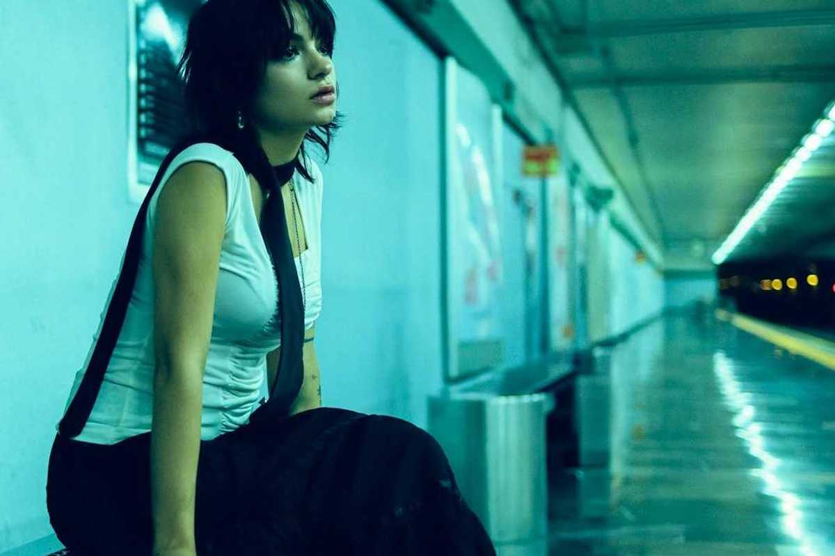 Woman seated on bench in underground station, waiting for train