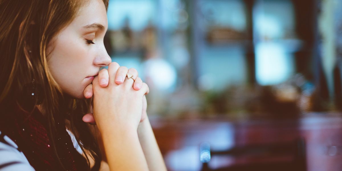 Woman with her hands folded in prayer