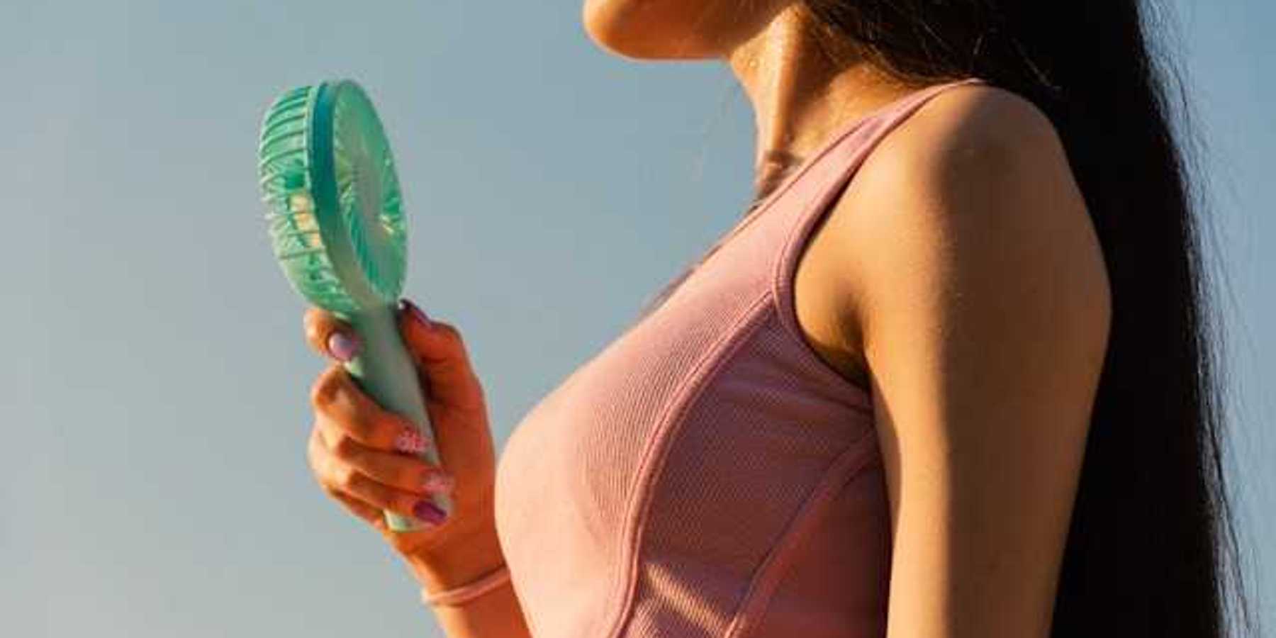 Woman with personal fan on a hot day