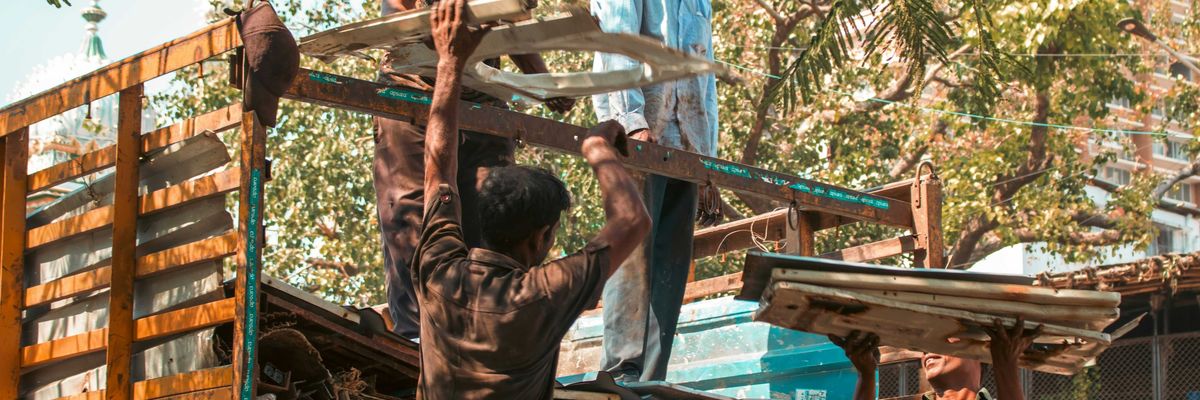 Workers loading scrap metal onto a truck.