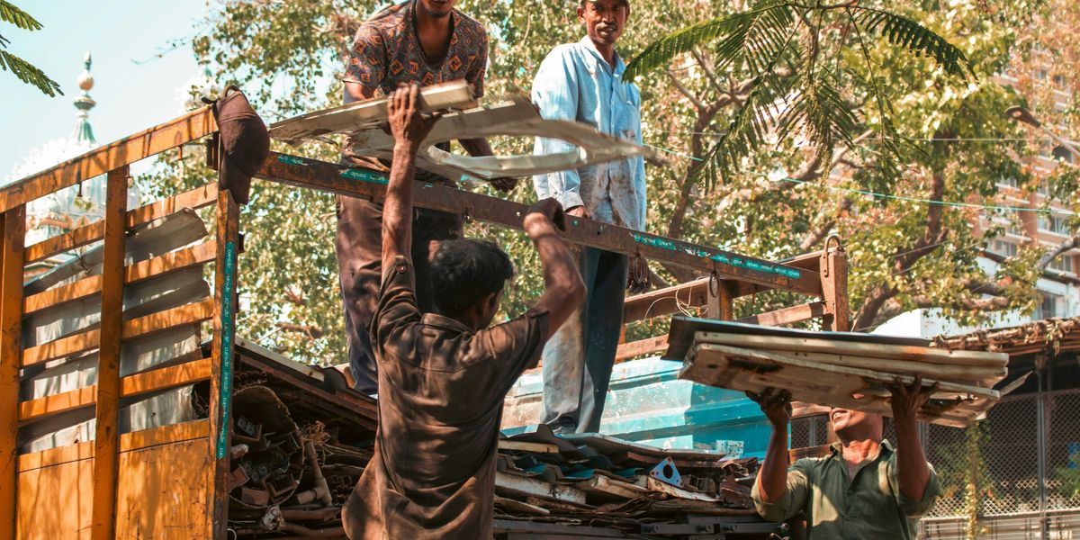 Workers loading scrap metal onto a truck.