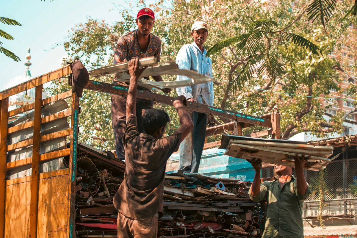 Workers loading scrap metal onto a truck.