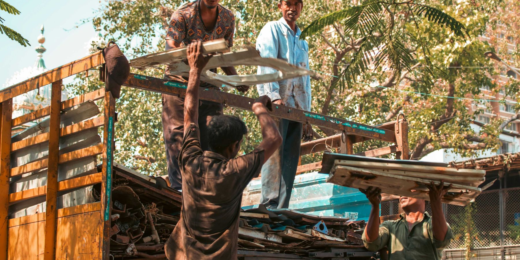 Workers loading scrap metal onto a truck.